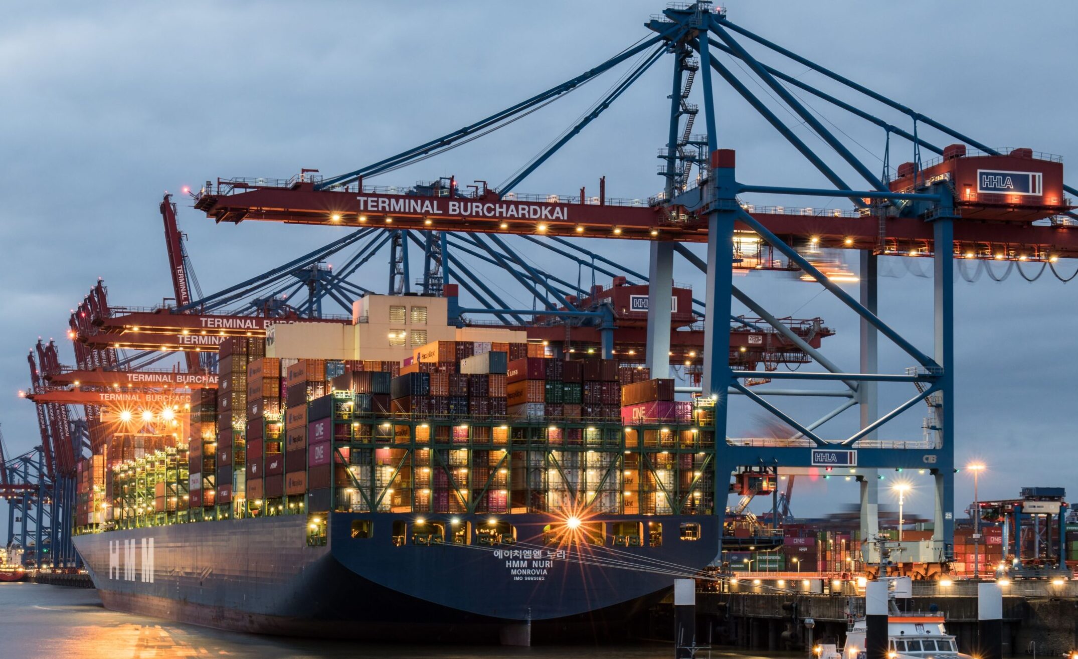 Container ships moored at Terminal Burchardkai in Hamburg, Germany during evening hours.